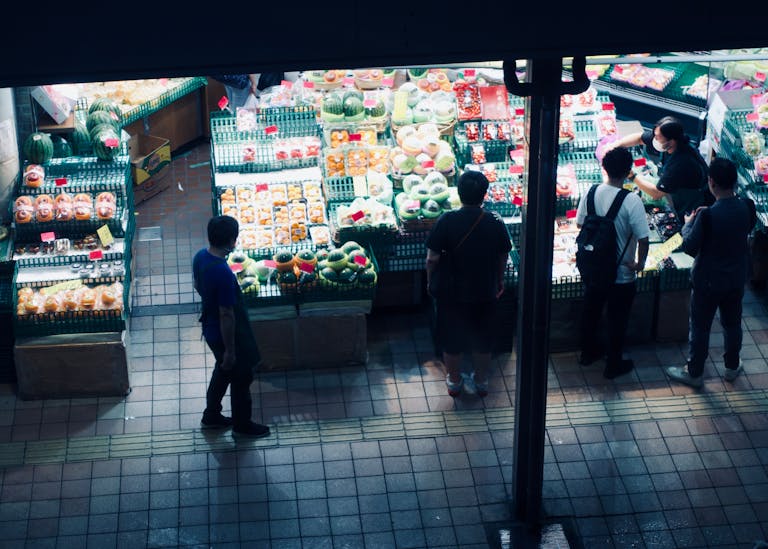 Vibrant night market scene showcasing a variety of fresh fruits and customers browsing.